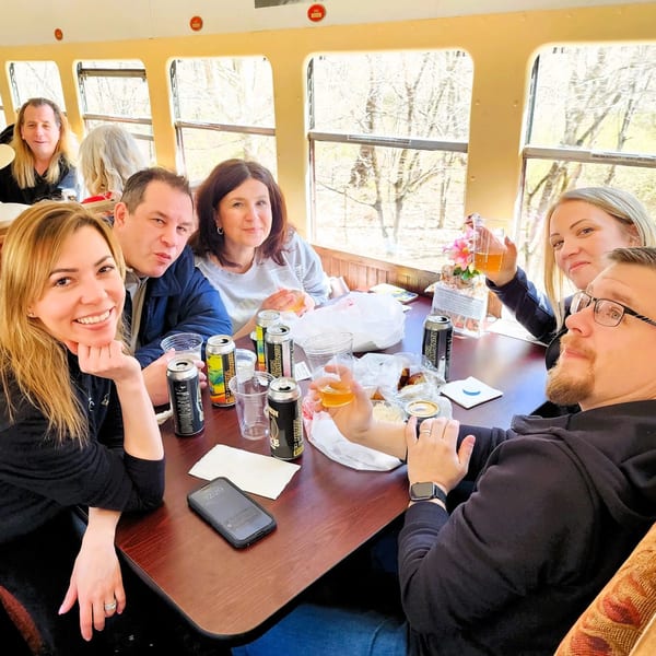 Group of friends enjoying Runaway Train Brewery beers and snacks inside a train car.